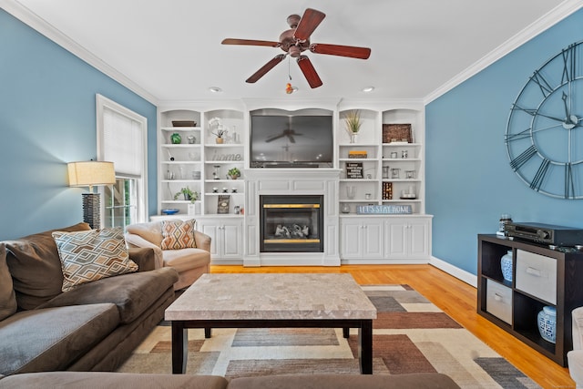 living room featuring ceiling fan, ornamental molding, and light hardwood / wood-style floors