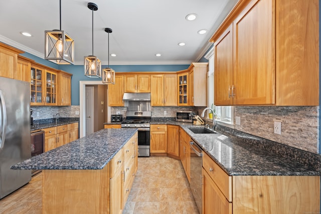 kitchen featuring a center island, stainless steel appliances, ornamental molding, sink, and dark stone counters