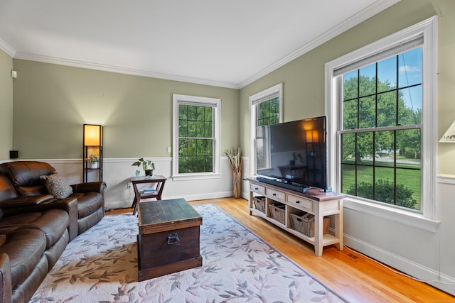 living room with light wood-type flooring and ornamental molding