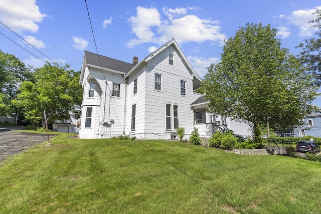 85 Aetna St Apt 12, Naugatuck, CT 06770 - view of front of home featuring a front yard, a chimney, and roof with shingles