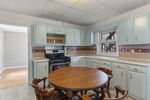 85 Aetna St Apt 12, Naugatuck, CT 06770 - kitchen with gas stove, a paneled ceiling, light countertops, baseboards, and tasteful backsplash