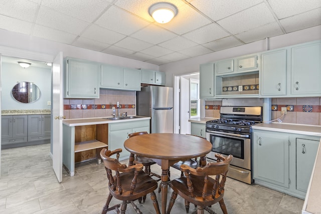85 Aetna St Apt 12, Naugatuck, CT 06770 - kitchen featuring stainless steel appliances, a paneled ceiling, backsplash, light countertops, and blue cabinetry