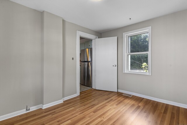 85 Aetna St Apt 12, Naugatuck, CT 06770 - unfurnished bedroom featuring freestanding refrigerator, light wood-type flooring, and baseboards