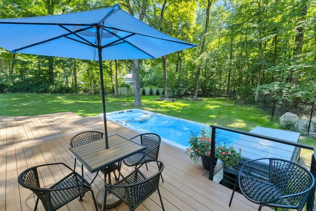 view of swimming pool featuring a wooden deck and a lawn