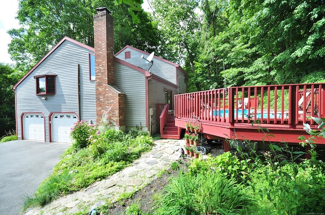 back of property with a garage and a deck