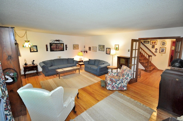 living room with wood-type flooring and a textured ceiling