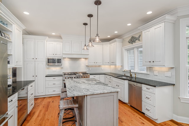 kitchen with a center island, white cabinets, dark stone countertops, and stainless steel appliances