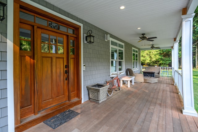 view of exterior entry with ceiling fan and a porch