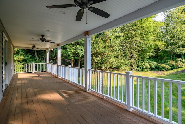 wooden terrace featuring a yard and ceiling fan