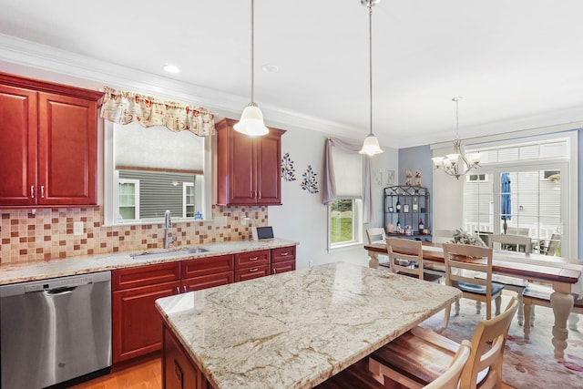 kitchen featuring hanging light fixtures, sink, dishwasher, a center island, and crown molding