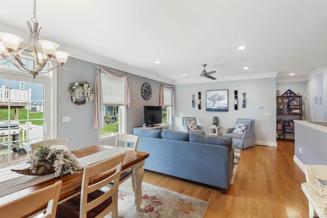 living room featuring ornamental molding, ceiling fan with notable chandelier, and light hardwood / wood-style flooring