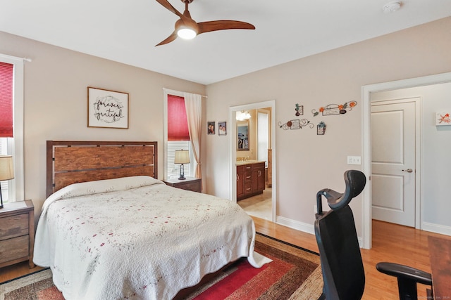 bedroom with light hardwood / wood-style floors, ensuite bathroom, and ceiling fan