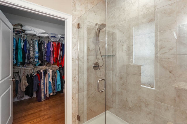 bathroom featuring hardwood / wood-style flooring and walk in shower