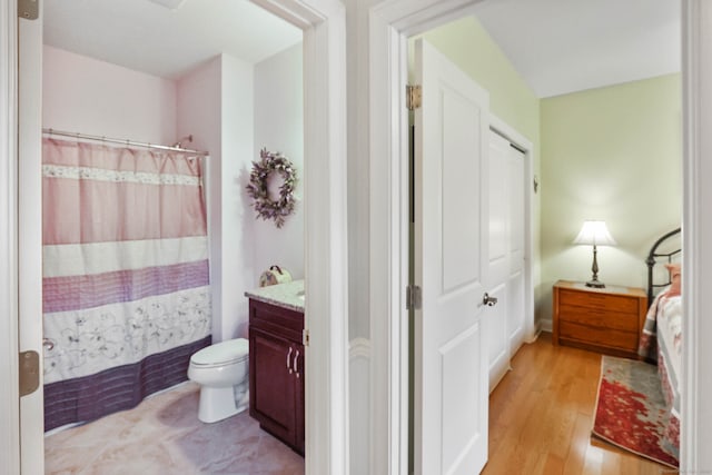 bathroom with a shower with curtain, hardwood / wood-style floors, vanity, and toilet