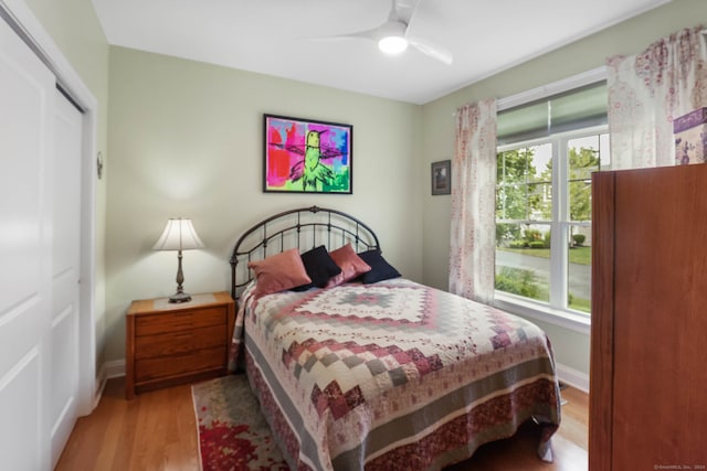 bedroom with ceiling fan, light hardwood / wood-style flooring, and a closet