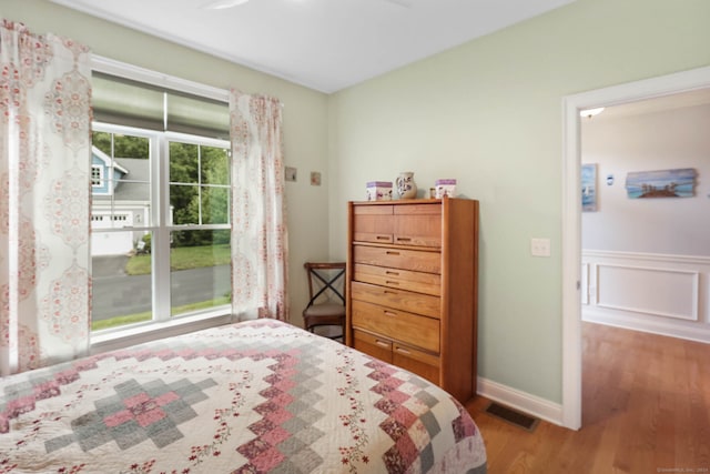 bedroom with multiple windows and wood-type flooring