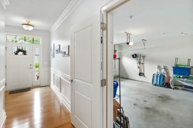 foyer with ornamental molding and light wood-type flooring