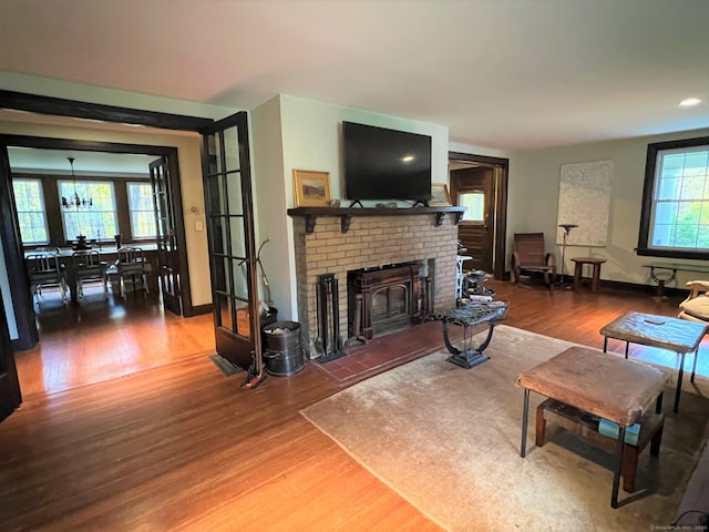 living room featuring a notable chandelier, hardwood / wood-style flooring, and a fireplace