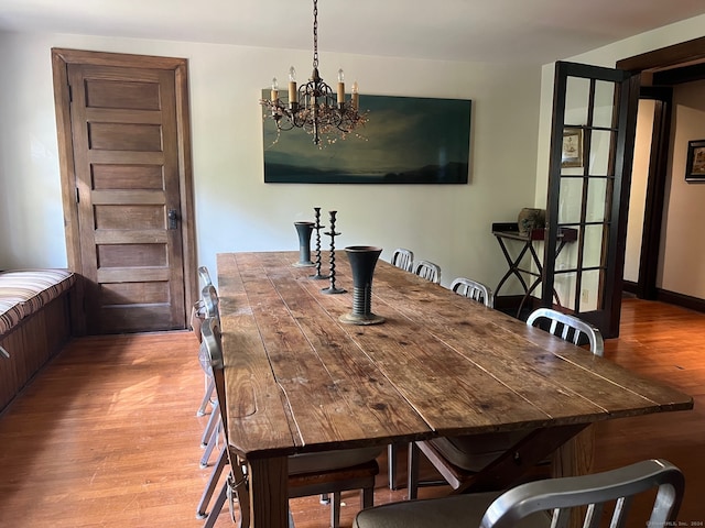 dining area with light wood-type flooring and a chandelier