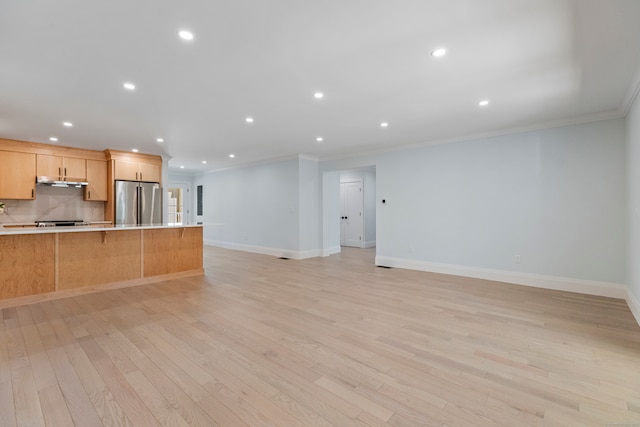 kitchen featuring light brown cabinets, stainless steel refrigerator, light hardwood / wood-style floors, and ornamental molding