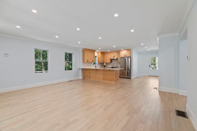 unfurnished living room featuring crown molding and light hardwood / wood-style floors