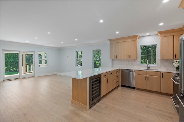 kitchen featuring beverage cooler, appliances with stainless steel finishes, plenty of natural light, and kitchen peninsula