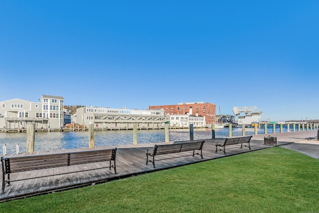 view of dock with a water view and a yard