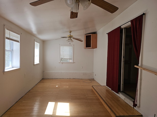 unfurnished room with ceiling fan, light hardwood / wood-style floors, and vaulted ceiling