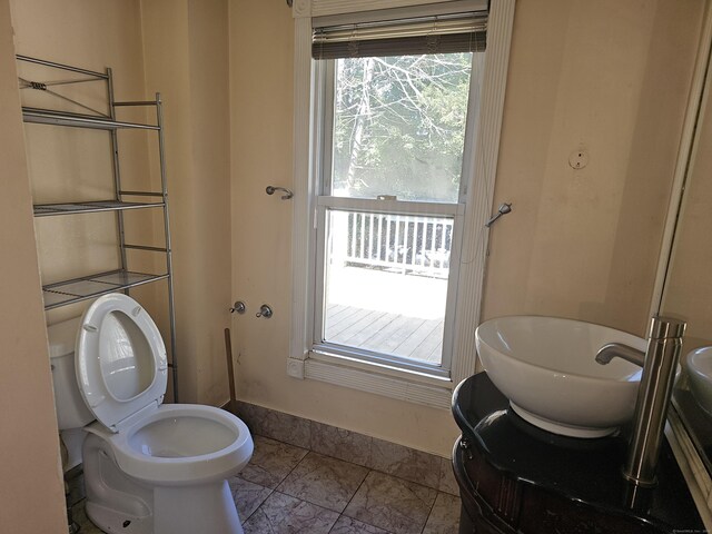 bathroom featuring tile patterned floors, toilet, plenty of natural light, and vanity