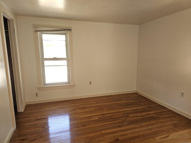 spare room featuring dark wood-type flooring