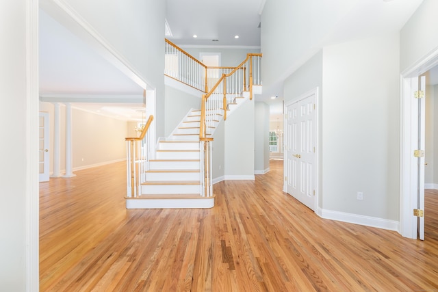 interior space featuring ornate columns, crown molding, and hardwood / wood-style flooring