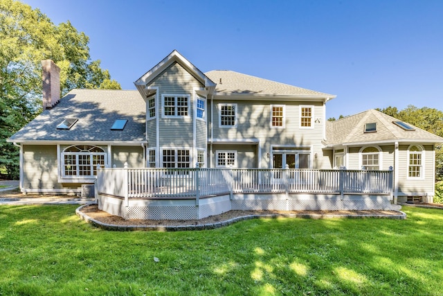 rear view of property with a lawn and a deck