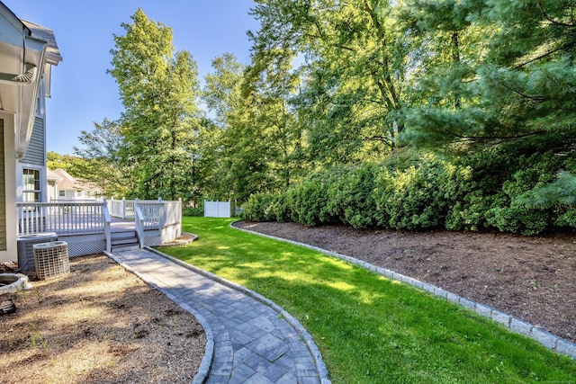 view of yard with central AC unit and a deck