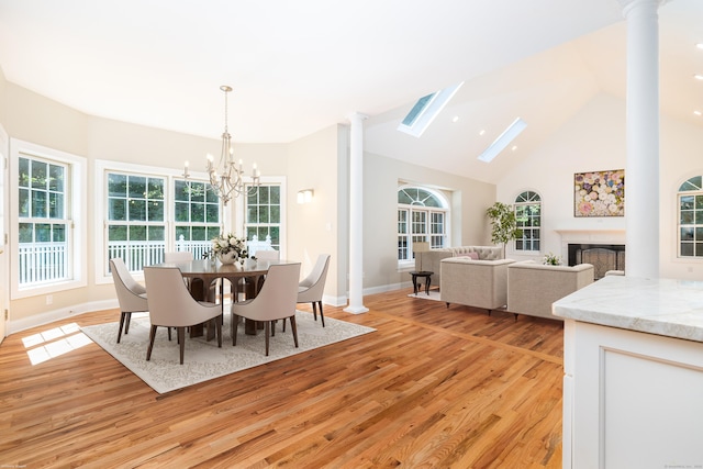 dining space featuring high vaulted ceiling, a chandelier, and light hardwood / wood-style flooring