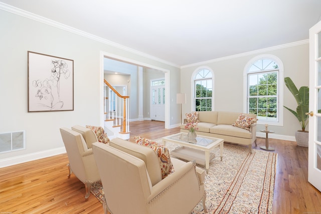 living room featuring crown molding and light hardwood / wood-style flooring