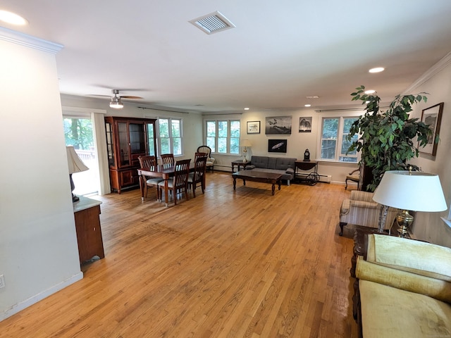 interior space with light wood finished floors, visible vents, baseboards, and ornamental molding