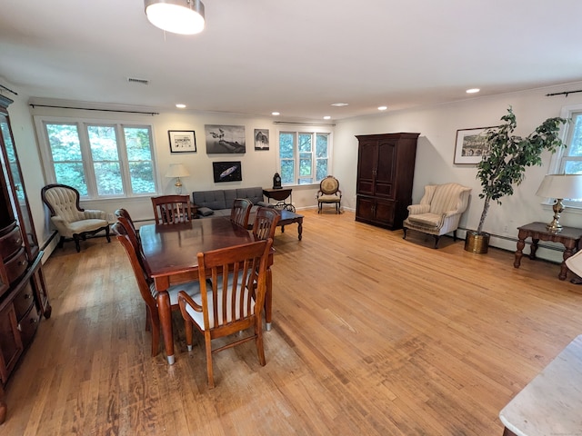 dining room featuring light wood-type flooring and a baseboard heating unit