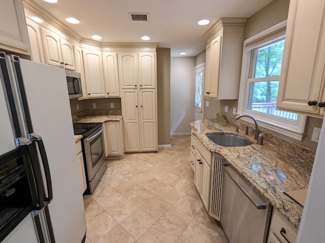 kitchen with light stone counters, visible vents, recessed lighting, a sink, and stainless steel appliances