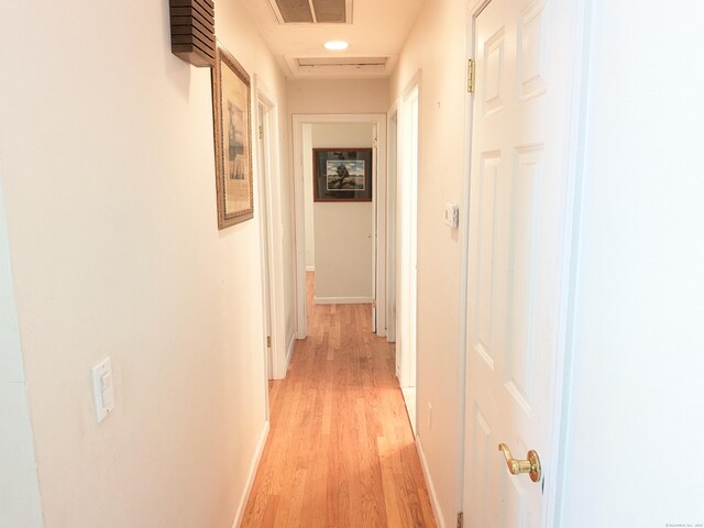 corridor with recessed lighting, baseboards, visible vents, and light wood finished floors