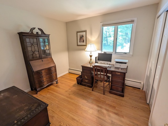 home office with light wood-type flooring, a baseboard heating unit, and baseboards