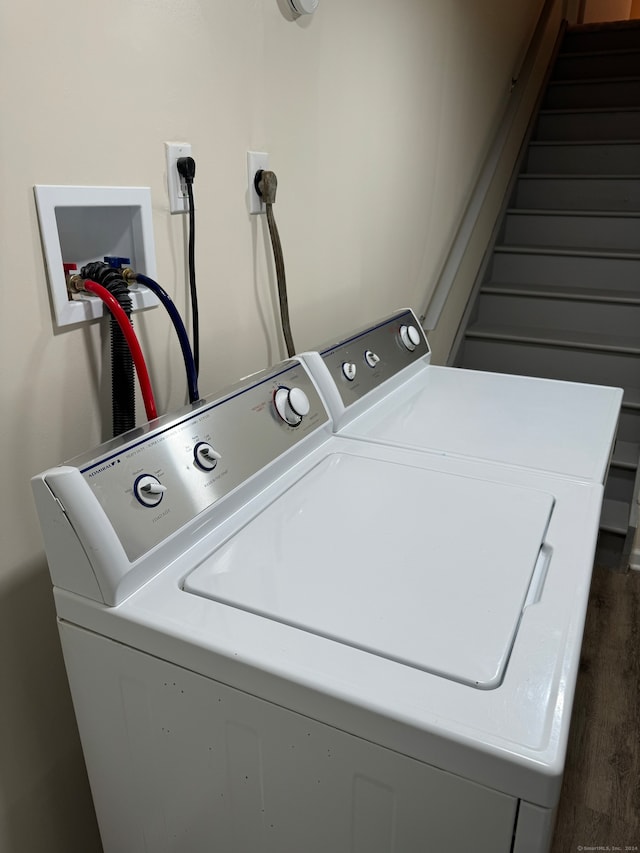 clothes washing area with washer and dryer and dark hardwood / wood-style flooring