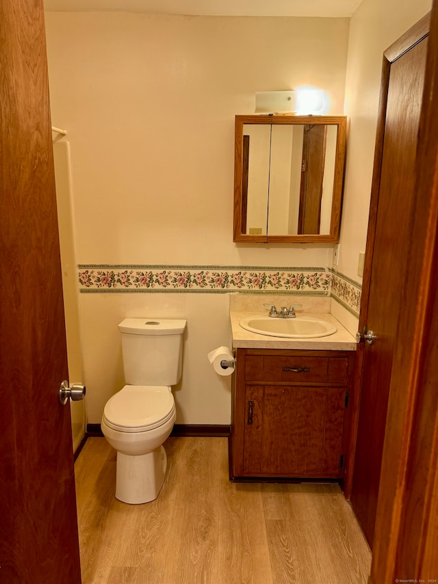 bathroom featuring vanity, hardwood / wood-style flooring, and toilet