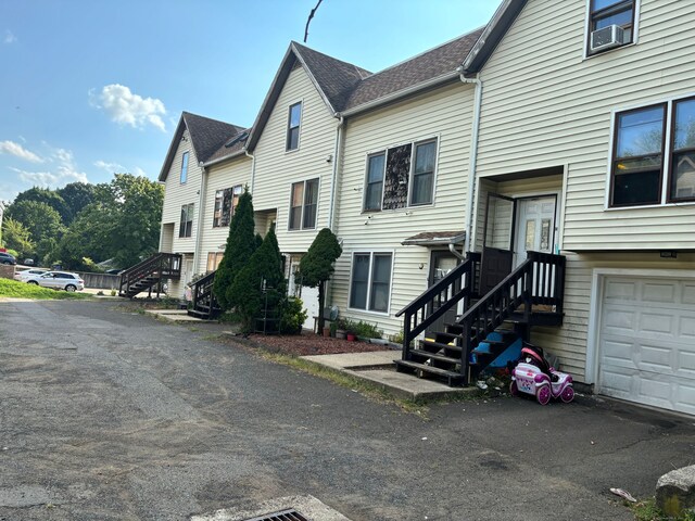 view of property exterior with cooling unit and a garage