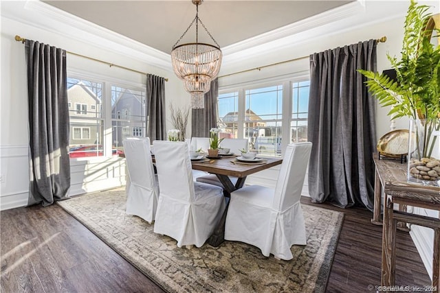 dining room featuring wood finished floors, an inviting chandelier, and ornamental molding