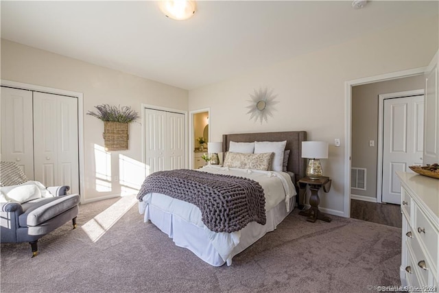 bedroom with carpet, visible vents, two closets, and baseboards