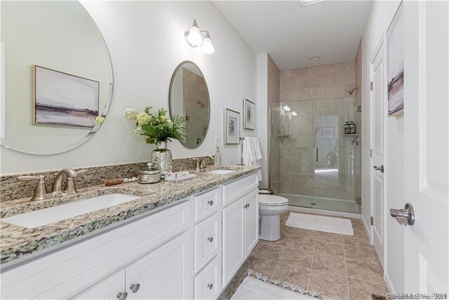 bathroom with vanity, toilet, an enclosed shower, and tile patterned floors