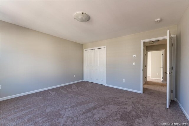 unfurnished bedroom featuring a closet and carpet floors