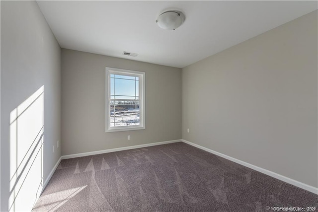 carpeted spare room featuring baseboards and visible vents