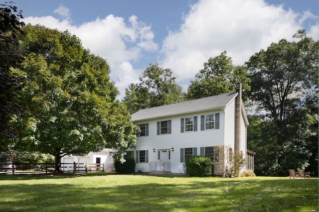 colonial inspired home with a front lawn