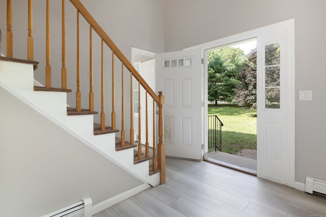 entryway with light wood-type flooring and a baseboard heating unit